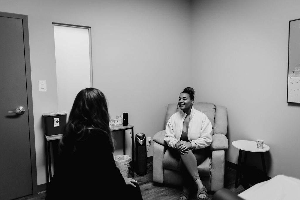 a woman sitting in a chair during a new patient intake session for acupuncture